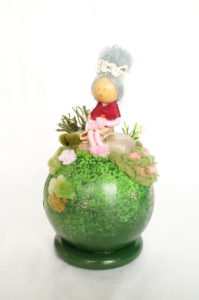 Objet décoratif avec planète miniature et personnage, mamie au jardin