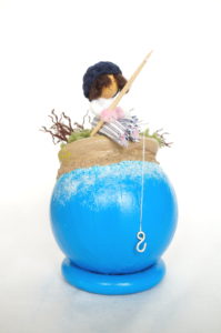 Objet décoratif avec planète miniature et personnage, pêcheur
